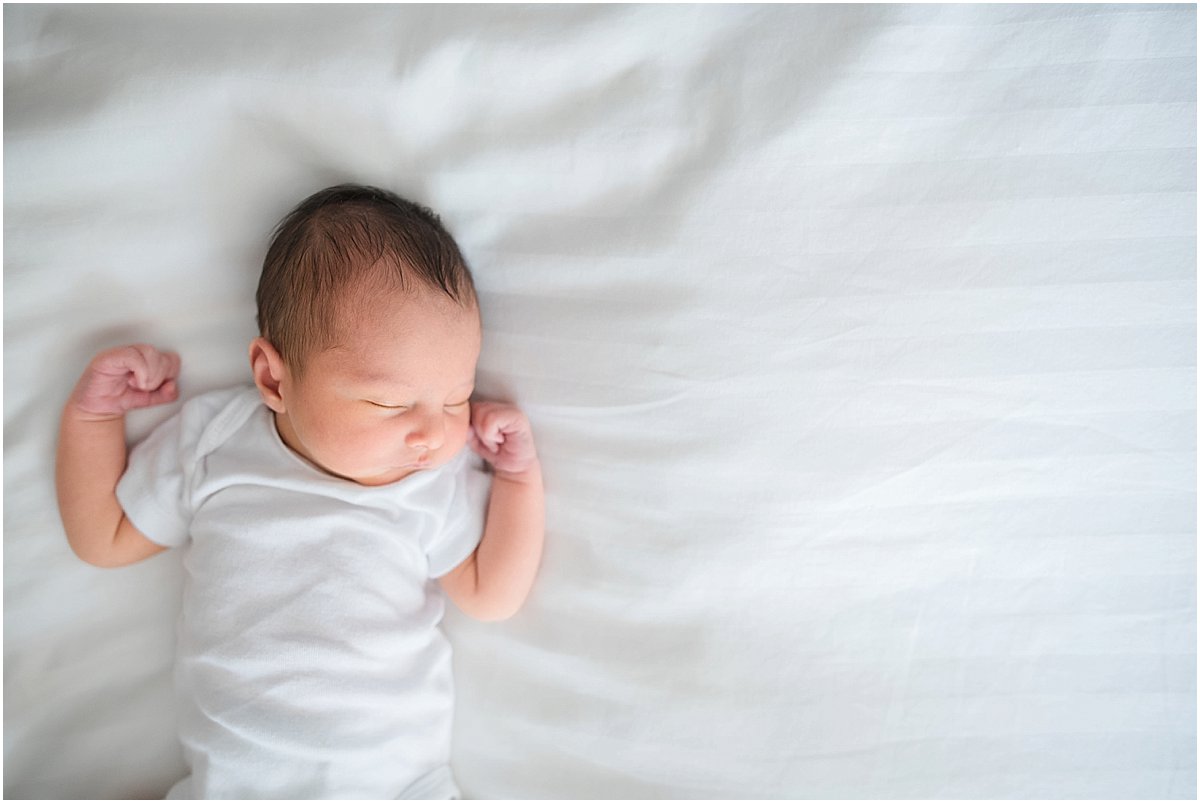 tiny newborn baby laying on bed. Non-posed orlando baby photographer.