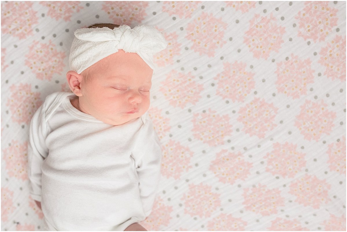 newborn baby sleeping on a swaddle blanket