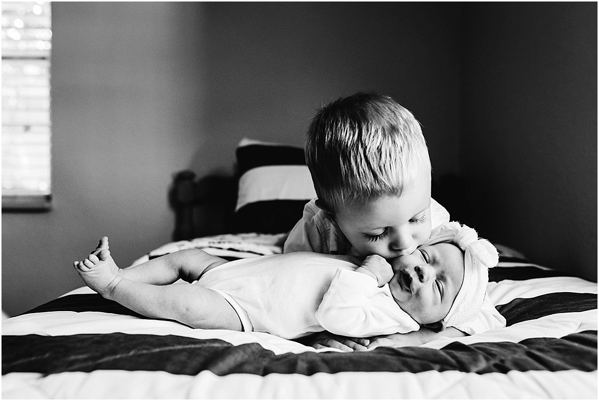 big brother kissing newborn baby sister | Orlando newborn photographer