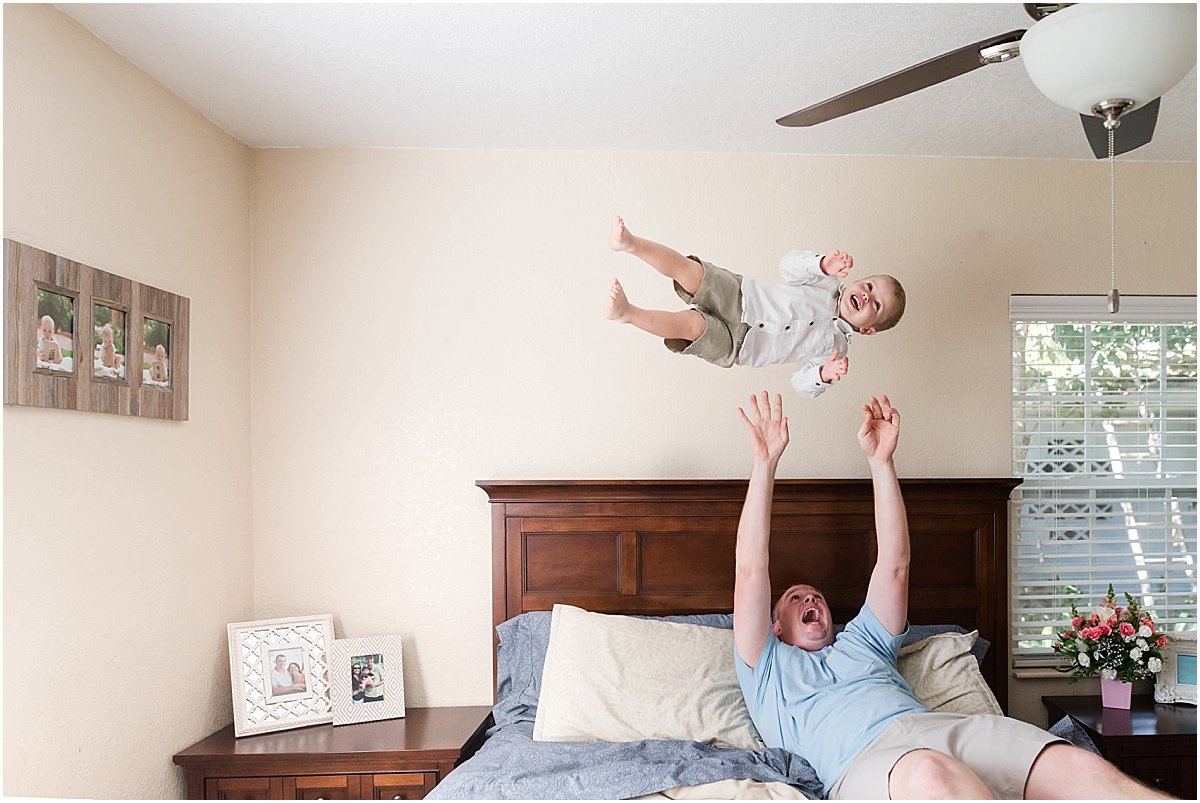 Dad throwing toddler son up in the air during in-home photo shoot | Orlando Family Photographer