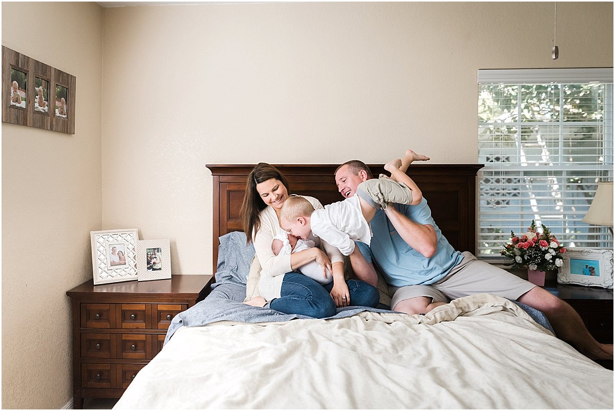 Family hanging out on bed during in-home non-posed newborn session | Orlando Newborn Photographer