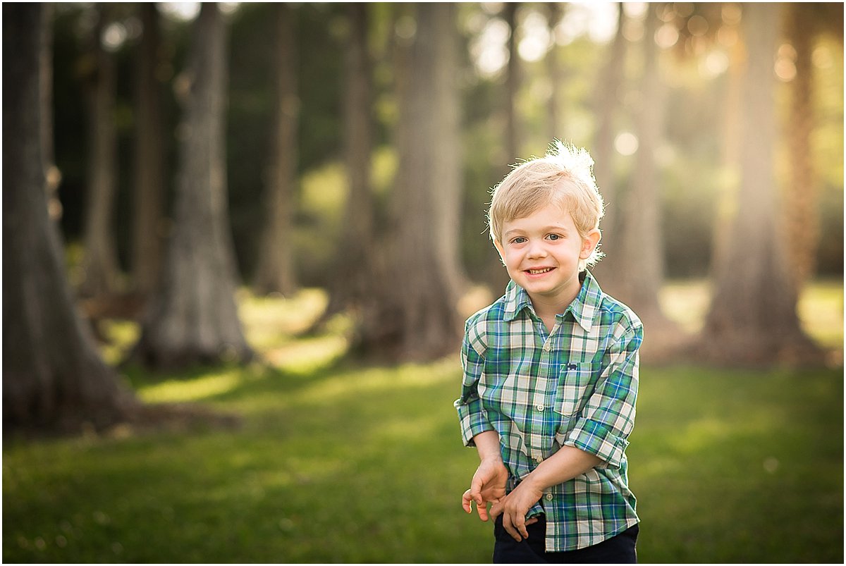  little boy giggling in the park during family photos 