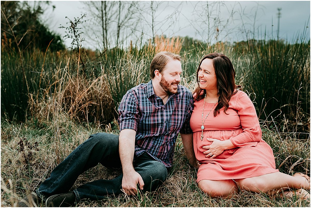 Pregnant mother with her hand on her belly and dad laughing | Orlando maternity photographer