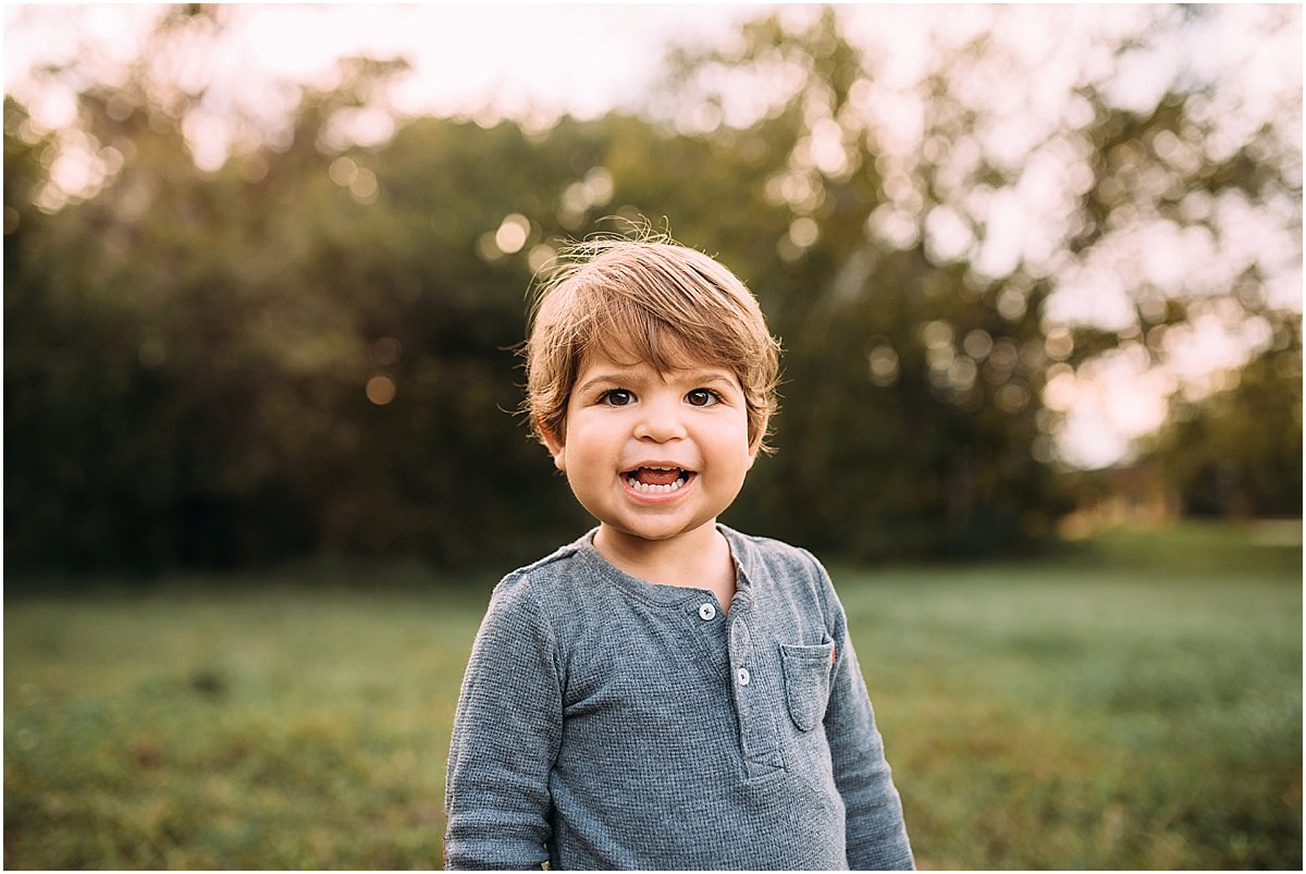 Little boy smiling in golden light for family photographs in Oviedo, Florida