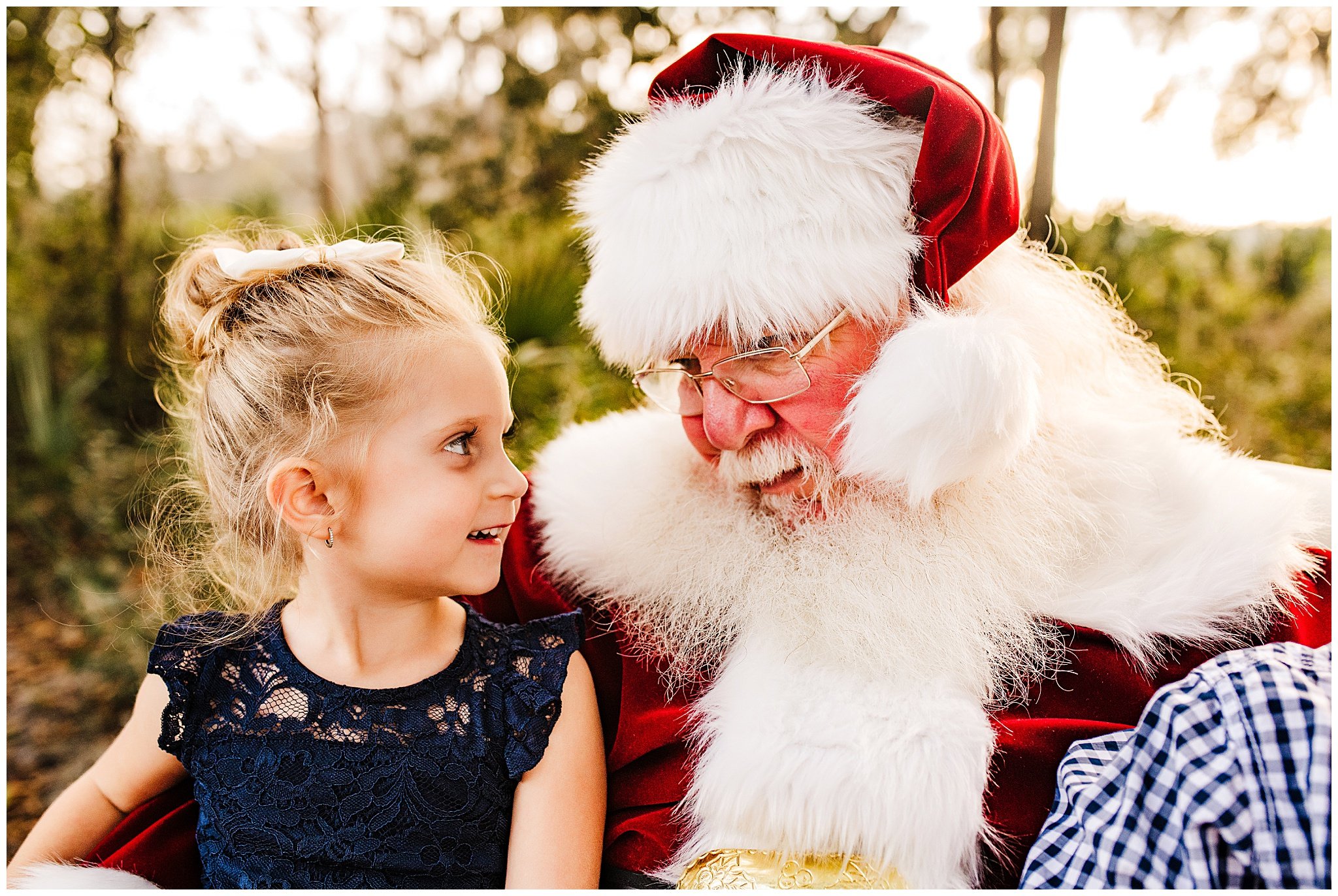 Picture of little girl looking at Santa and Santa looking back at her. 