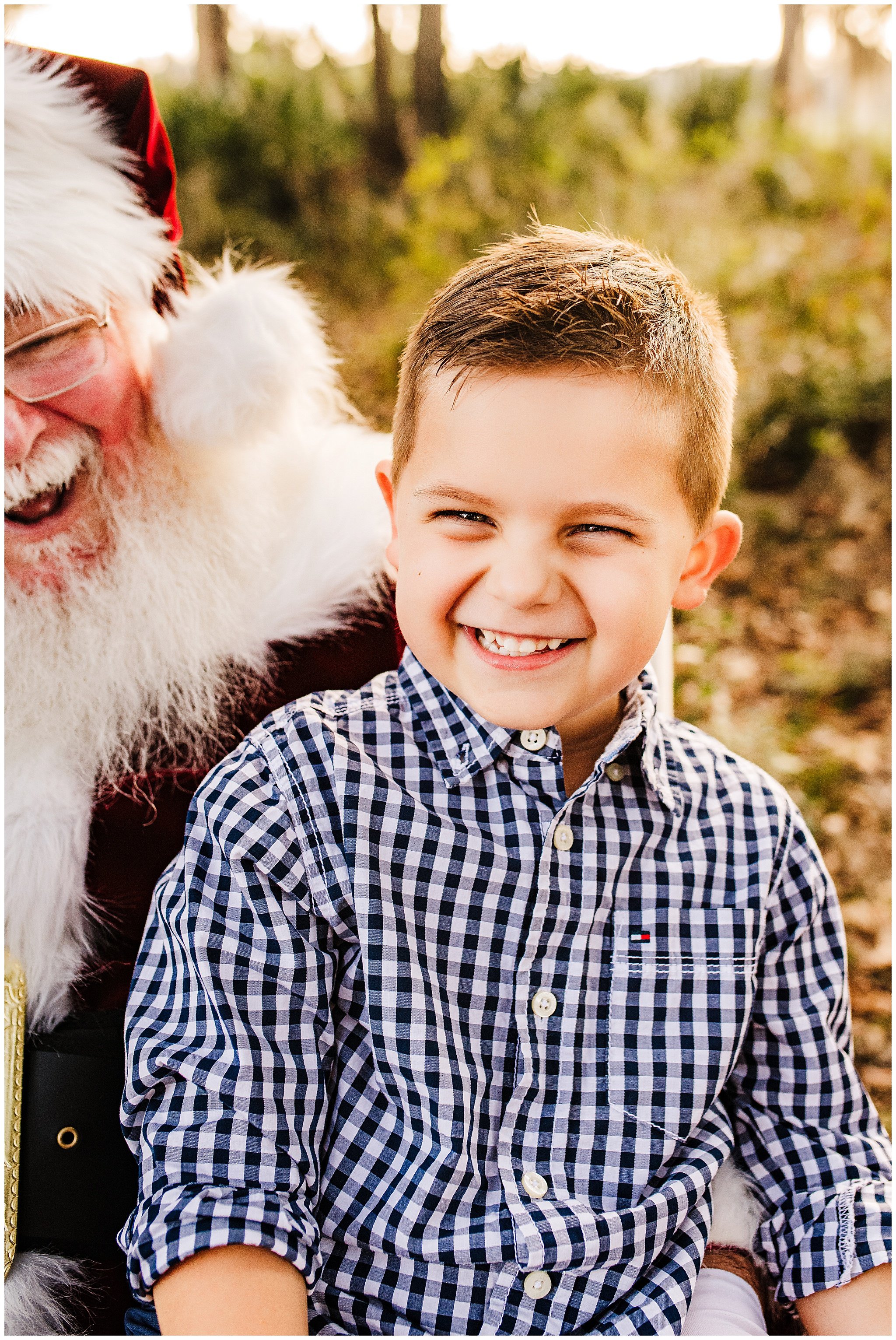 Photo of young boy laughing on Santa Claus' lap.