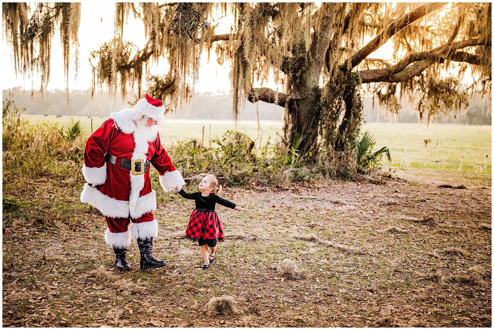 Young child walking with Santa Claus in an outdoor park near Orlando, Florida