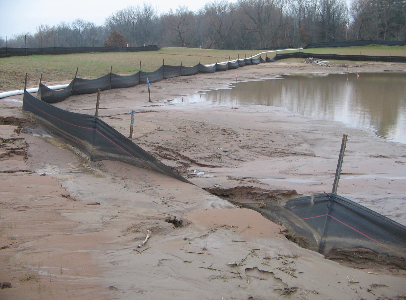 Lower flow rates, improper T-Post spacing, & non-reinforced silt fence fabric combine for a failed install.