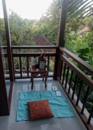 That’s my laundry bag acting as a rug so that the floor doesn’t feel too cold. The little table was some stool for the desk. The Buddha was room decoration that I fetched off the wardrobe closet. And the cushions belong to the bed. But the postcards are mine! Easy to travel with!… As a long-time meditator, one of the things I’ve learned is that the set up really doesn’t matter. You just basically sit anywhere you can, make it kind of nice, and rest the mind.