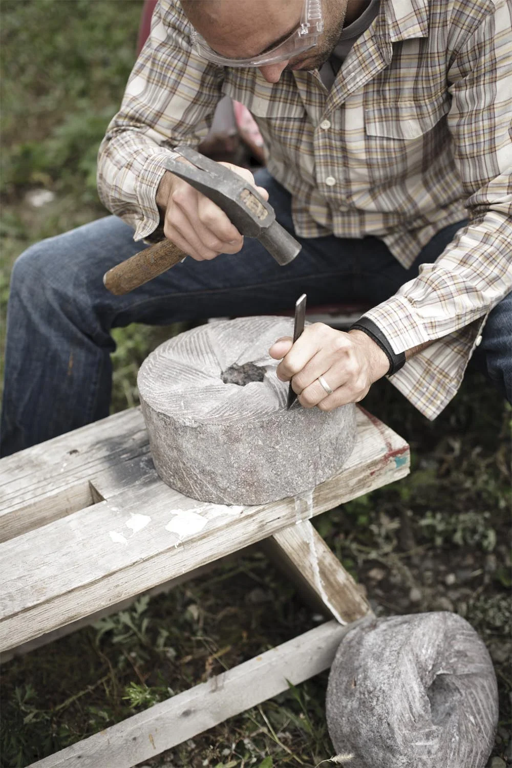Owner Alex Whitmore carving patterns into a stone for grinding chocolate
