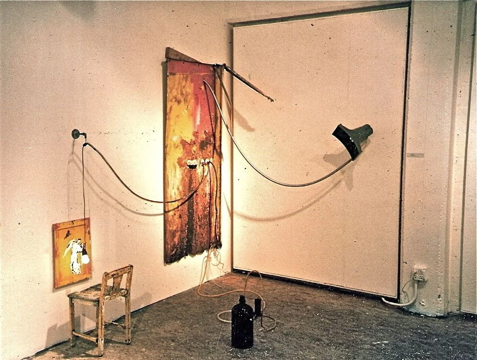    System 1    1995  Steel shower enclosure panel, loudspeaker, child's chair, cabinet door, cables, wires, light bulb, hardware, found objects dimensions variable, here approx. 7' h x 8' w x 6' d 