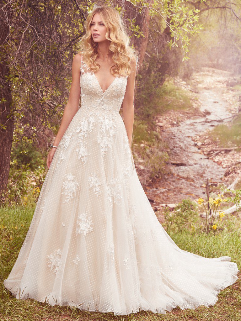Meryl - This vintage-inspired wedding dress features lace appliqués over whimsical layers of dotted tulle and Chic organza. Featuring a V-neckline, illusion straps accented with lace appliqués, and square back. Swarovski crystals and beading add shimmer and ethereal texture to this ballgown. Finished with covered buttons over zipper closure. Colors Available - White, Ivory, Ivory/Light Gold