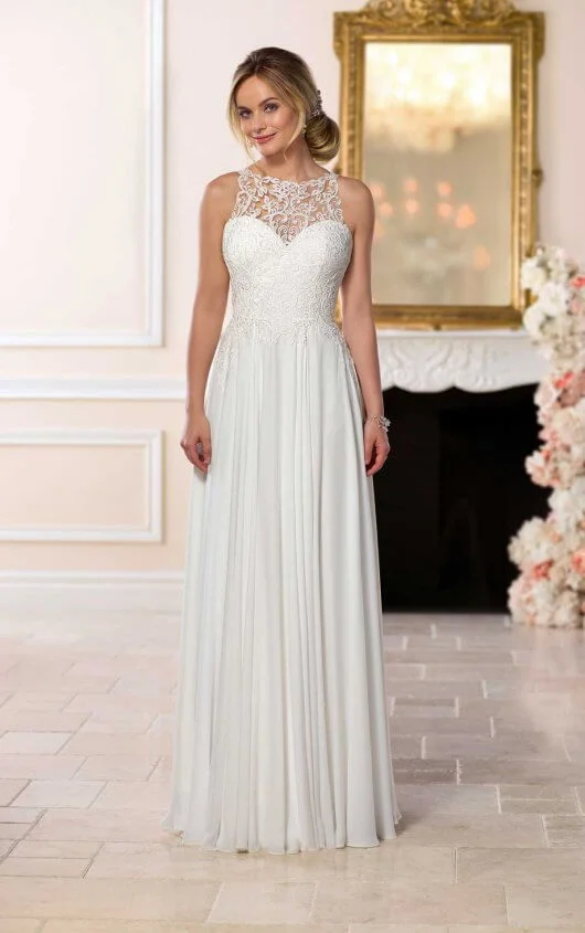 6593 - Perfect for a beach wedding, this chiffon wedding dress from designer Stella York is simply sweet. Lace and crepe chiffon create an easy-to-wear sheath silhouette with a boho halter neckline and natural waistline. The rich chiffon skirt is breezy and romantic and plays well off of the boho lace of the bodice. The lace applique flows onto the skirt and highlights the train in very subtle but impactful style. This light and beachy style’s clean lines are complemented by a cameo lace illusion back, which meets just above the small of the bride’s back. The matte fabrics allow for the details of the lace to stand out and only add to the beach feeling of this wedding dress. This easy-to-wear wedding dress zips under fabric-covered buttons and is also available in plus sizes. Colors Available - White, Ivory 