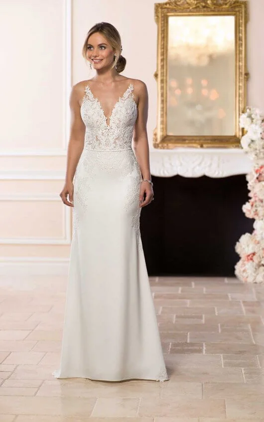 6648 - Modern meets sexy in this sleek silhouette by wedding dress designer Stella York. Matte lace and silky crepe create a sheath silhouette with plunging V-neckline and naked illusion back. The sheer V-shaped bodice is created by matte lace with an organic finish that adds a botanical look to the lace. Available in -
