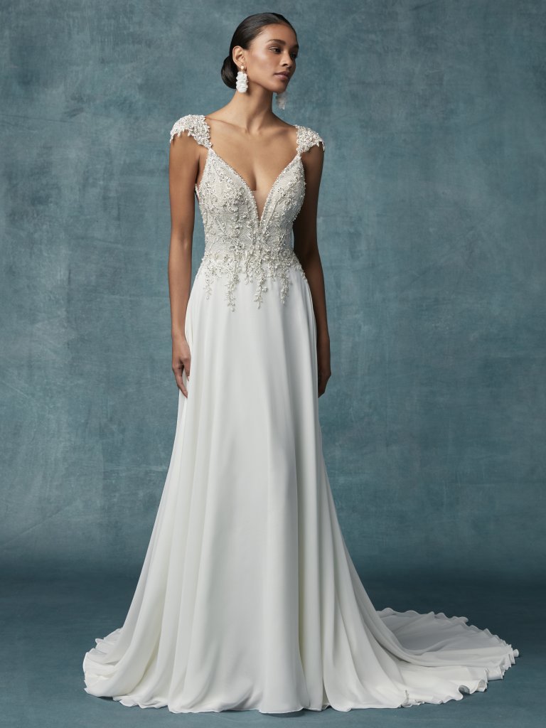 Gabor - This Grecian-inspired wedding dress features a bodice accented in beaded lace motifs and Swarovski crystals atop a Georgette chiffon A-line skirt. Beaded lace motifs comprise the sheer cap-sleeves, gliding from illusion plunging sweetheart neckline to unique strap detail in the back. Finished with crystal buttons over zipper closure. Available in: Ivory/Silver, Ivory/Nude/Silver