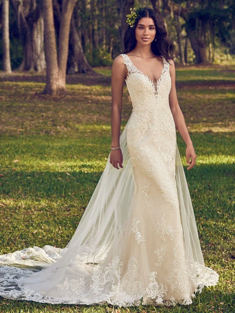 Bernadine - Beaded lace motifs dance over tulle in this sheath wedding dress, accenting the illusion plunging V-neckline, illusion straps, and illusion back with keyhole. Finished with covered buttons over zipper closure. Detachable tulle train accented in lace motifs sold separately. Available in: White, Ivory, Ivory/Champagne