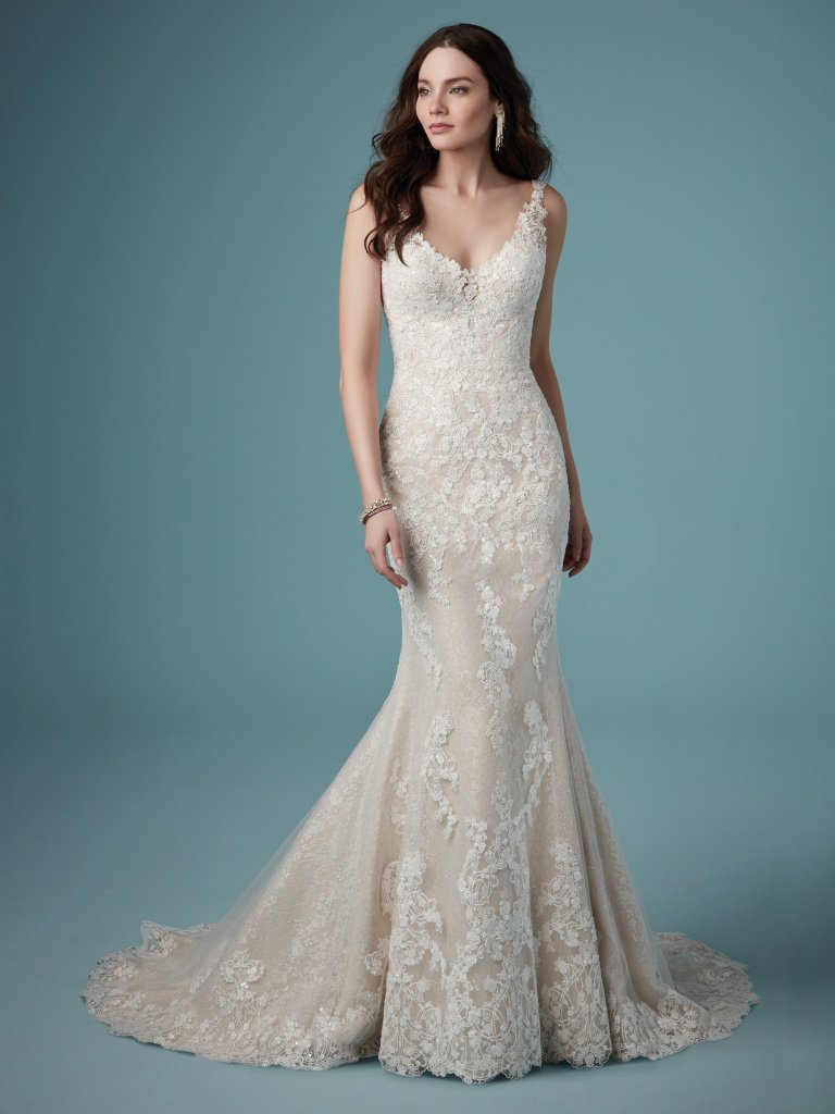 Ambrose - This lovely fit-and-flare wedding dress is delicately embroidered with lace motifs over Chantilly lace. Featuring an illusion V-neckline, V-back, and lace straps. Finished with covered buttons over zipper closure. Available in: Ivory, Ivory/Blush