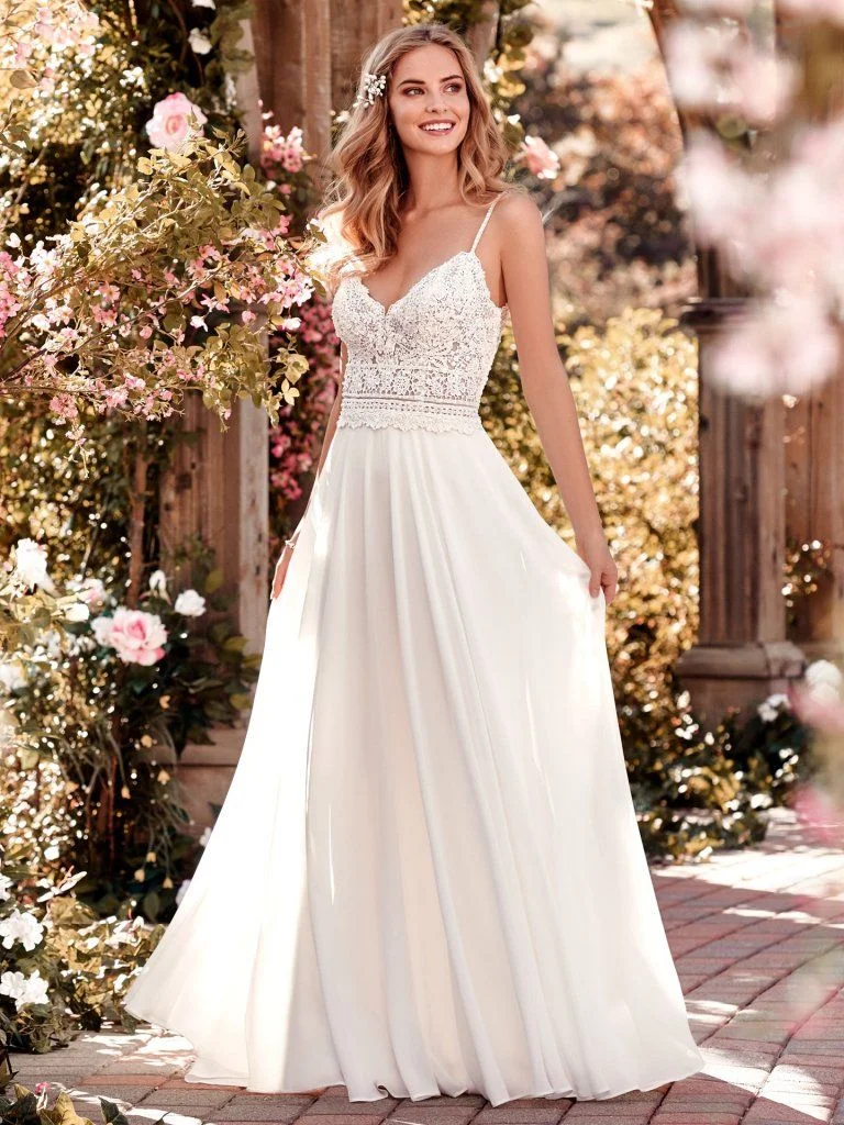 Juniper - This chiffon boho-inspired wedding dress features a sheer bodice accented in beaded lace atop an Aria Chiffon skirt. A V-neck, V-back, and beaded spaghetti straps complete this sheath gown. Finished with crystal buttons and zipper closure. Available in plus size. Available in: White, Ivory