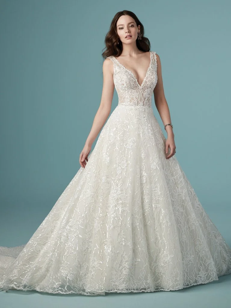 Ricarda - Stunning allover sequin lace brings a beautiful sparkle to this A-line wedding dress featuring a lined lace bodice, deep V-neckline, and V-back. Finished with crystal buttons over zipper closure. Includes center front modesty panel for added coverage. Available in plus size. Available in: All Ivory, Ivory/Alabaster