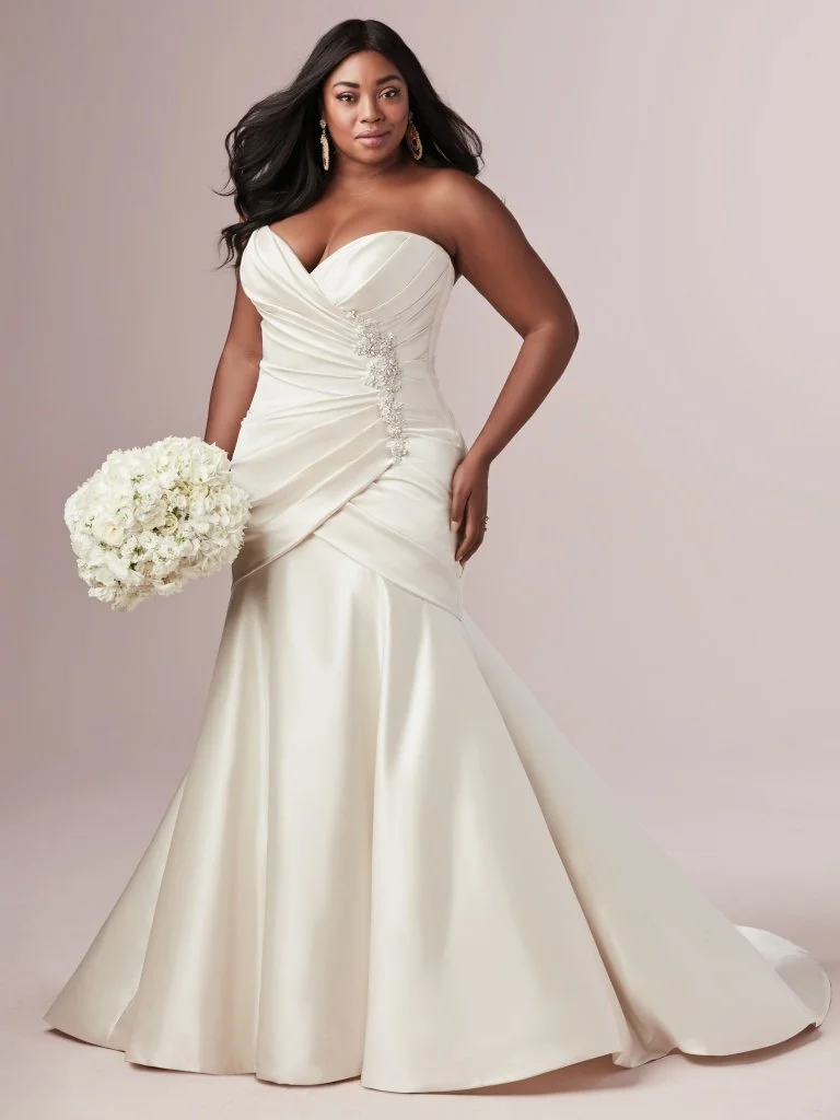 Maisey - This stunning strapless fit-and-flare wedding dress is comprised of L‘Amour satin with asymmetrical pleating creating a slimming silhouette. Detailed with a beaded motif with Swarovski crystals and sweetheart neckline. Finished with covered buttons over zipper and inner corset closure. Available in plus size. Available in: Ivory, Alabaster