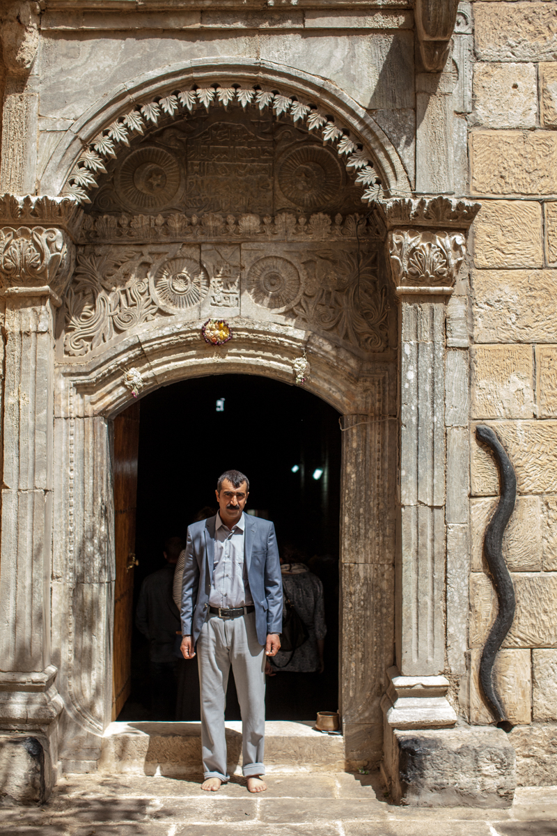  Tariq, a Yazidi man from Sinjar, who fled his home in 2014 stands barefoot inside the holy temple of Lalish (2016). 