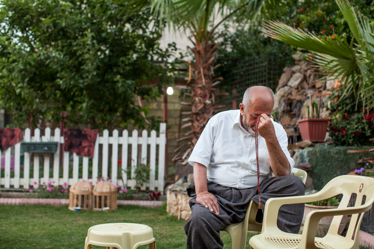  Father of the Omer family prays. He is occasionally the mu'azzin, the person appointed at a mosque to lead and recite the call to prayer for every event of prayer and worship in the mosque - Iraqi, Kurdistan (2016). 