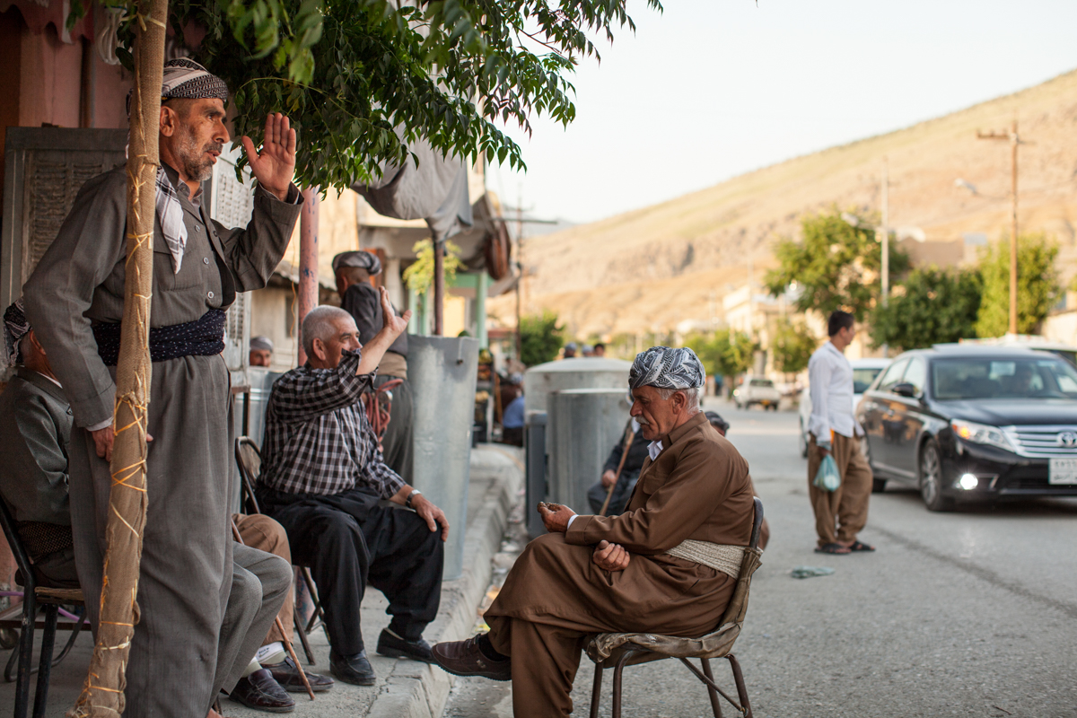  Kurdish men wave to a friend from the roadside - Soran, Iraq (2016). 