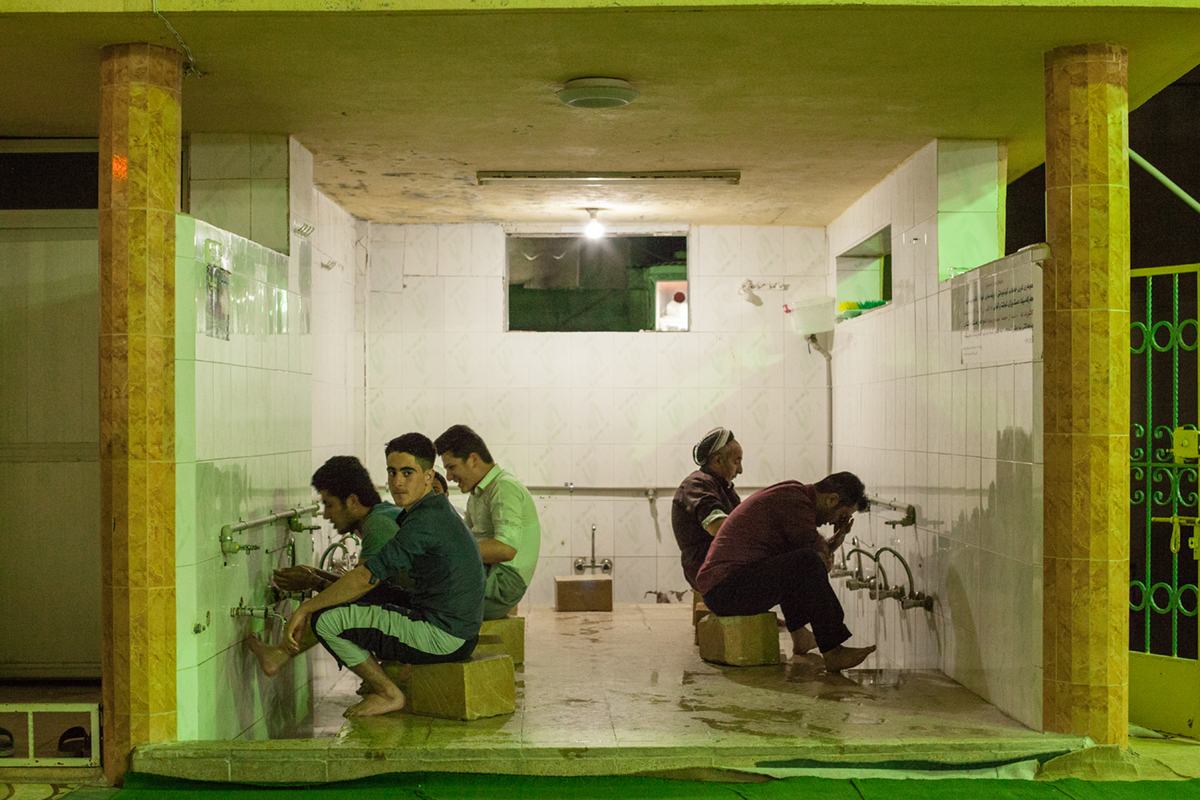  Men wash their feet in preparation for evening prayers at a mosque in Northern Iraq (2016). 