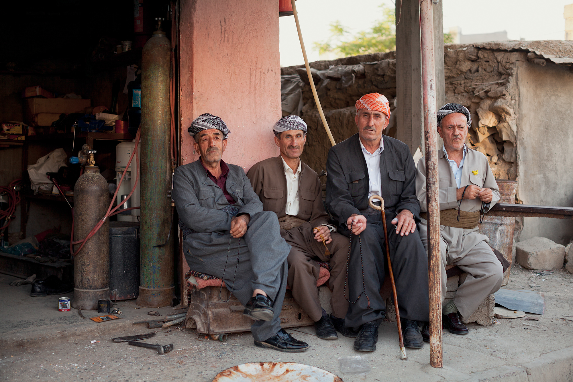  Four Kurdish men sit atop a car engine in Soran, Iraq (2016). 