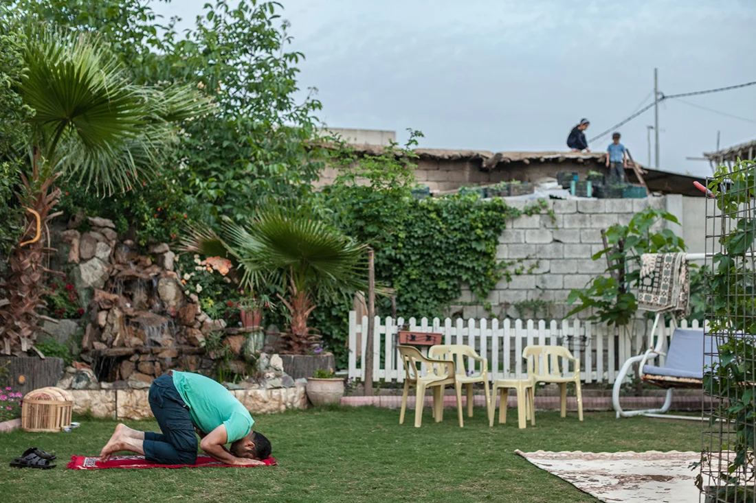 Two children climb from rooftop to rooftop in Soran, Iraq while Wedya, a Kurdish Muslim, prays evening prayers (May 2016).