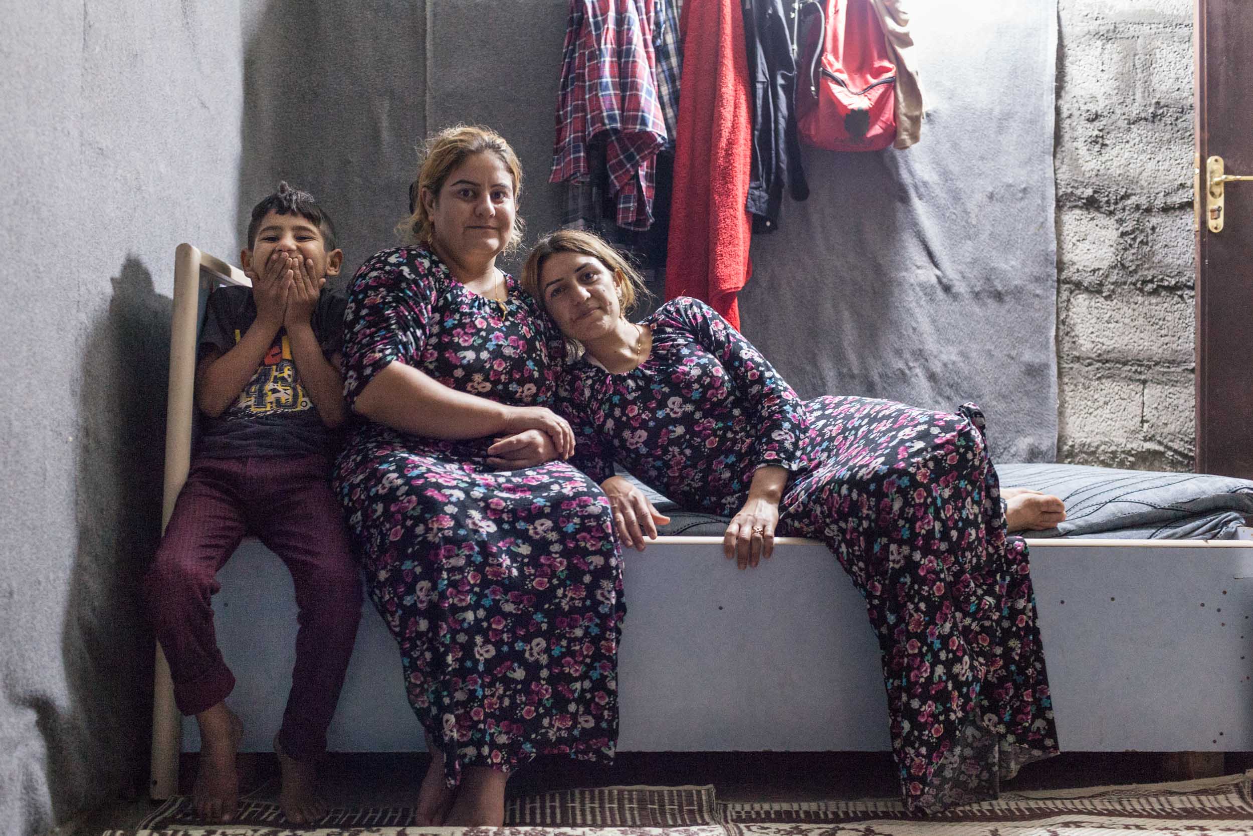  Yazidi sisters and boy inside their cinderblock home at their camp in Azadi, Iraq (2016). 