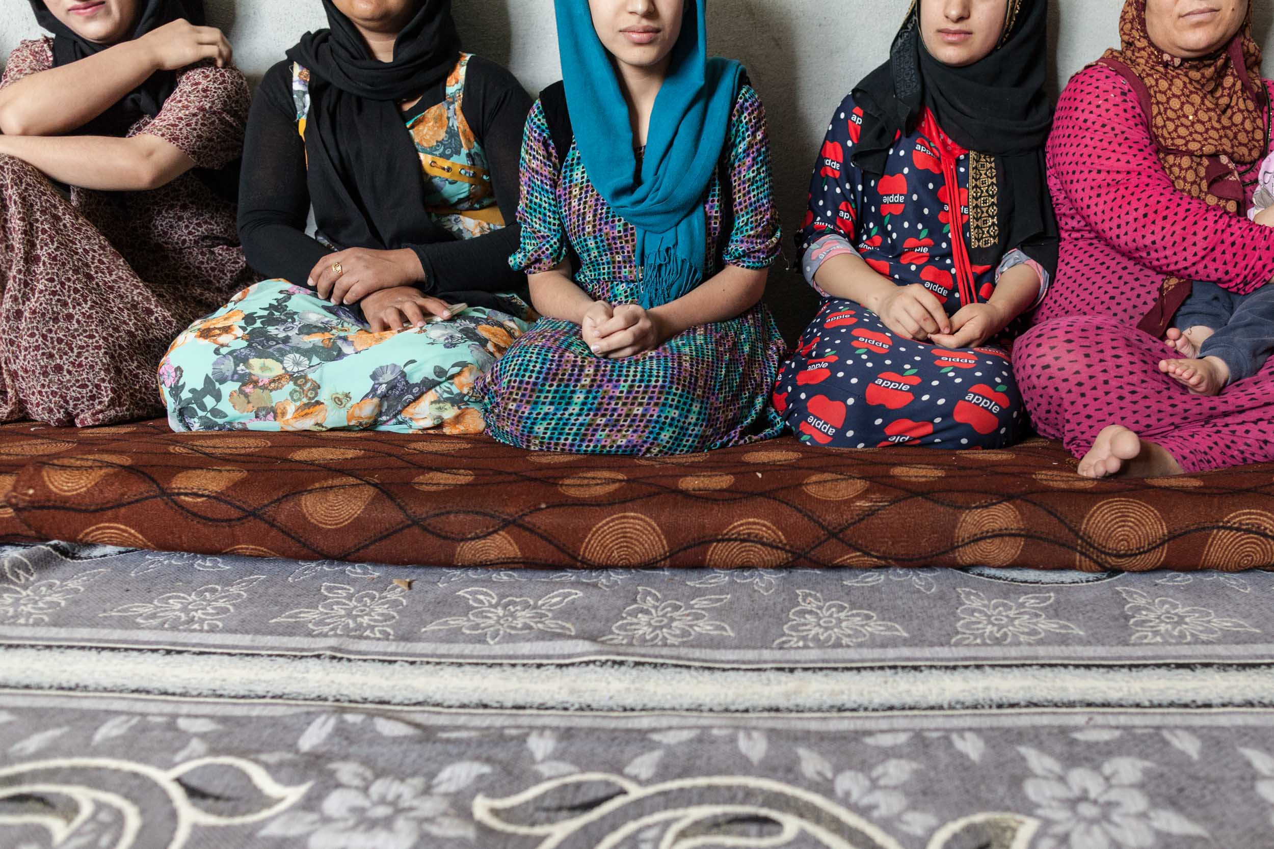  Women sit inside a home at Azadi refugee camp for PTSD counseling (2017). 