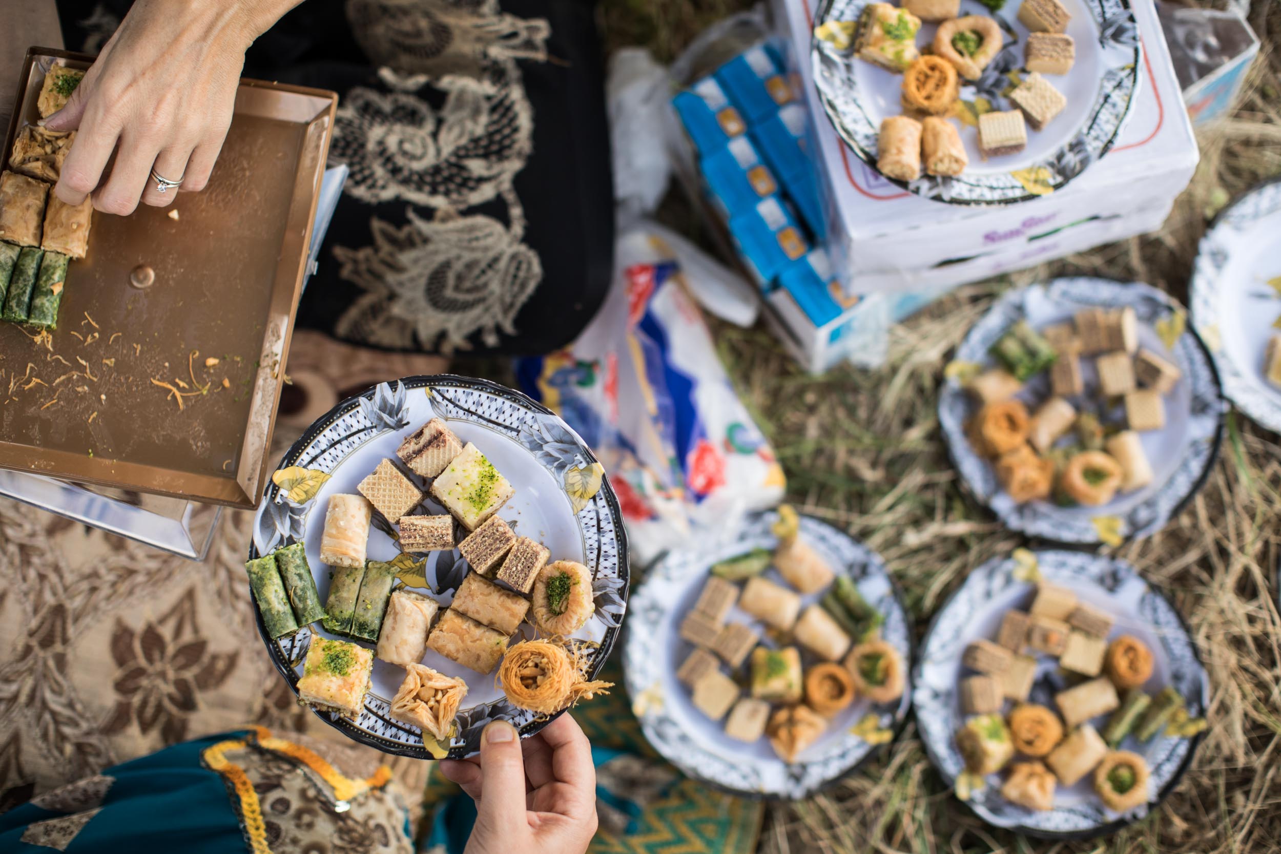  Yazidi women prepare dessert plates at a refugee camp in Akoyan, Iraq (June 2017). 