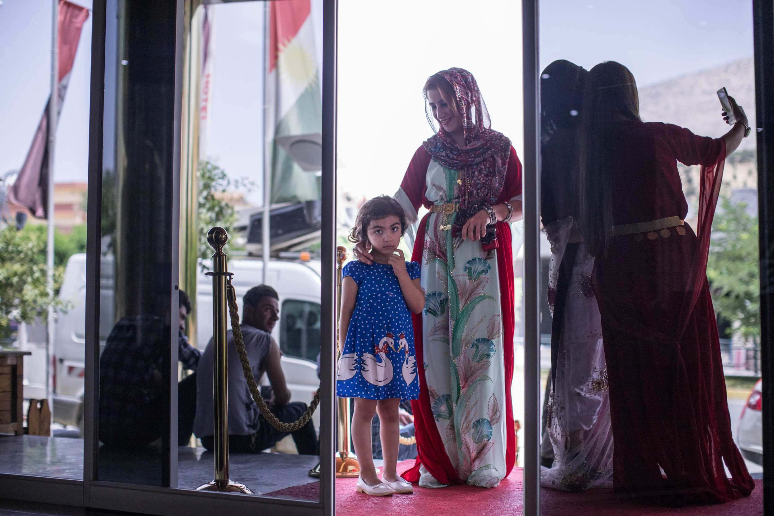  Family await the arrival of the bride and groom to go to their wedding outside a hotel lobby in Soran, Iraq (2017). 