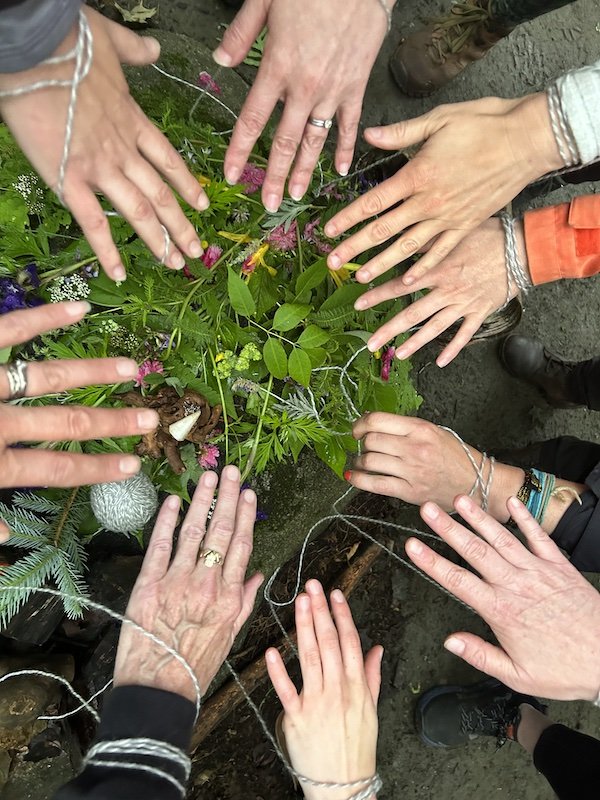 hands connecting around a plant altar