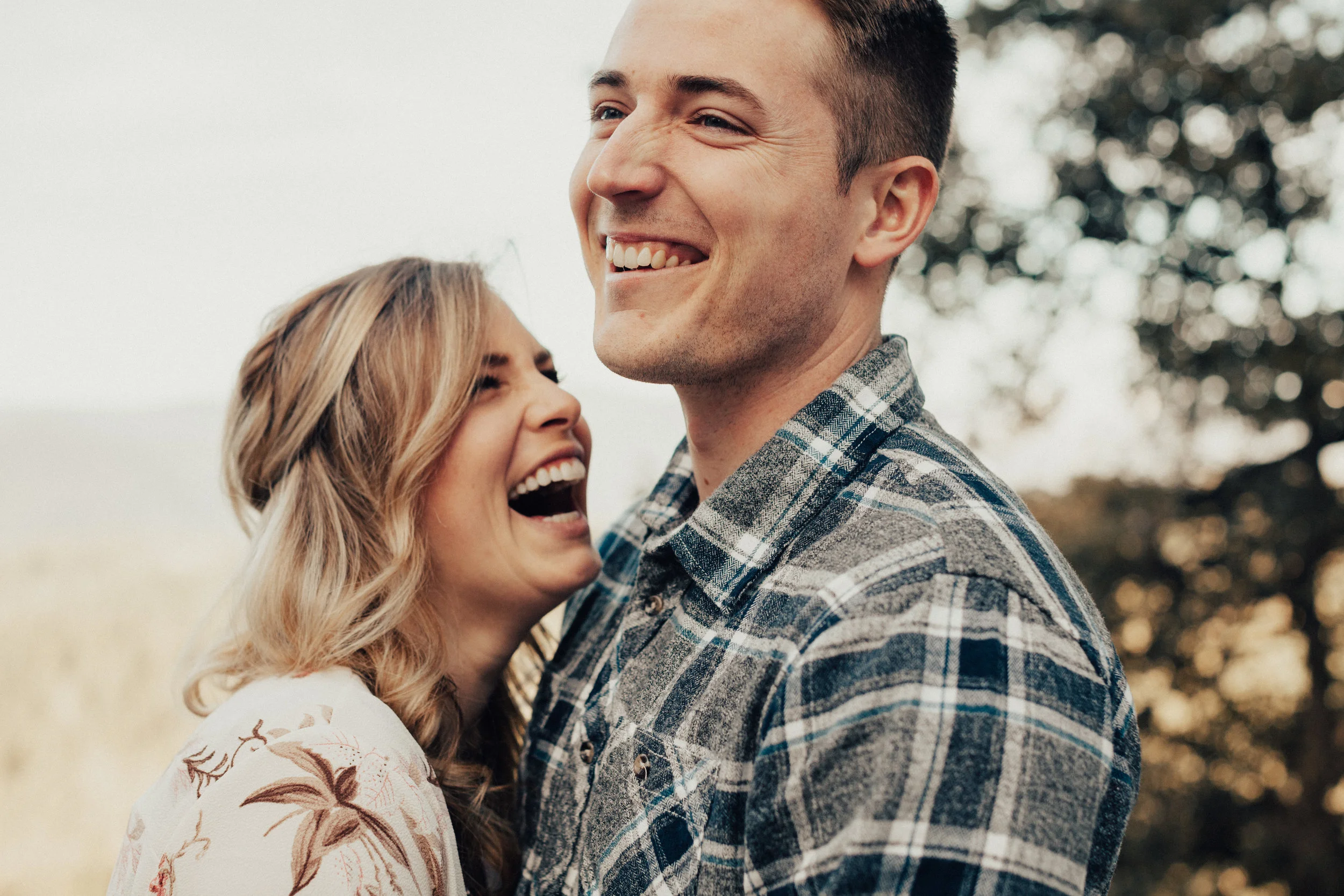 Couple laughing hysterically together during their engagement session. 