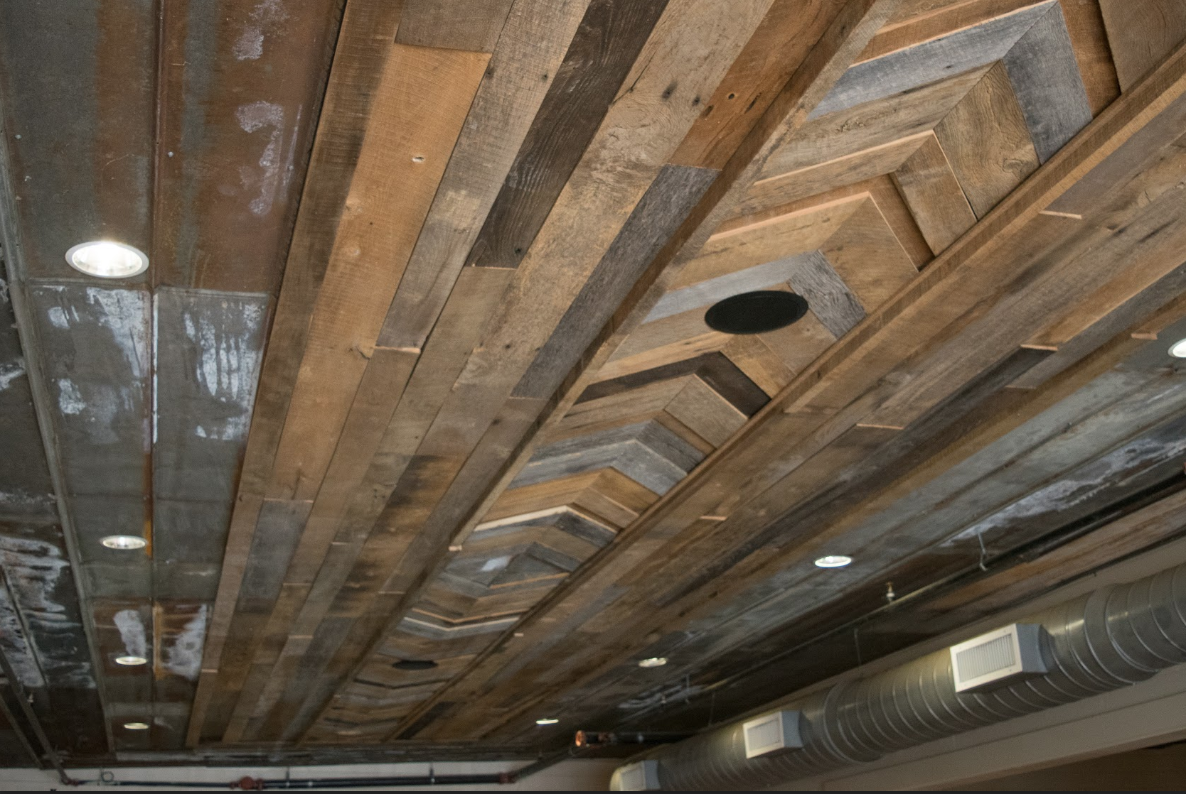 The ceiling of the private dining rooms are covered with a design of reclaimed barn wood and tin