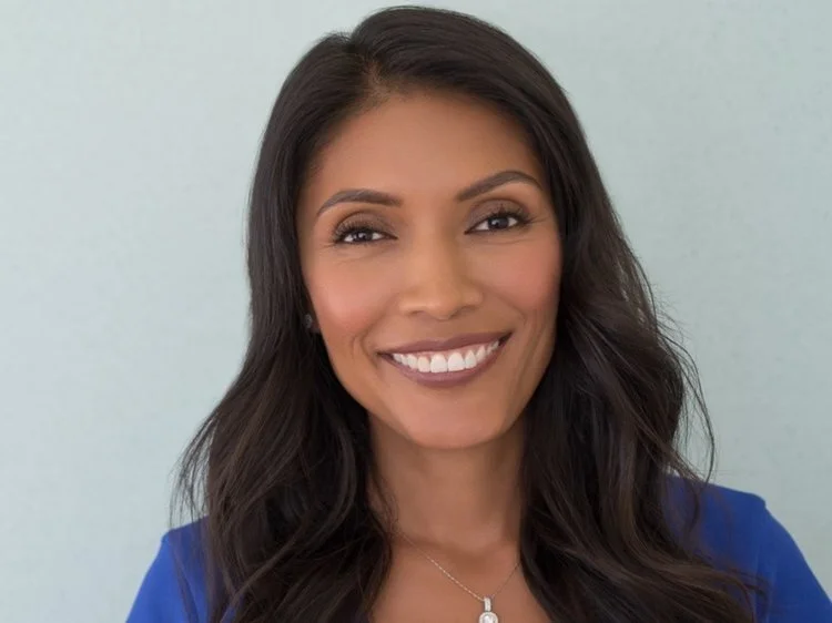 Bernice Maldonado wears a silver necklace and blue top. She has long, wavy dark hair, and smiles brightly.