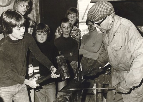 Smedemester Gunnar Hansen med elever fra Blovstrød Skole i smedjen på hjørnet af Kongevejen og Blovstrød Byvej. 1977. Foto: Lokalhistorisk Arkiv.