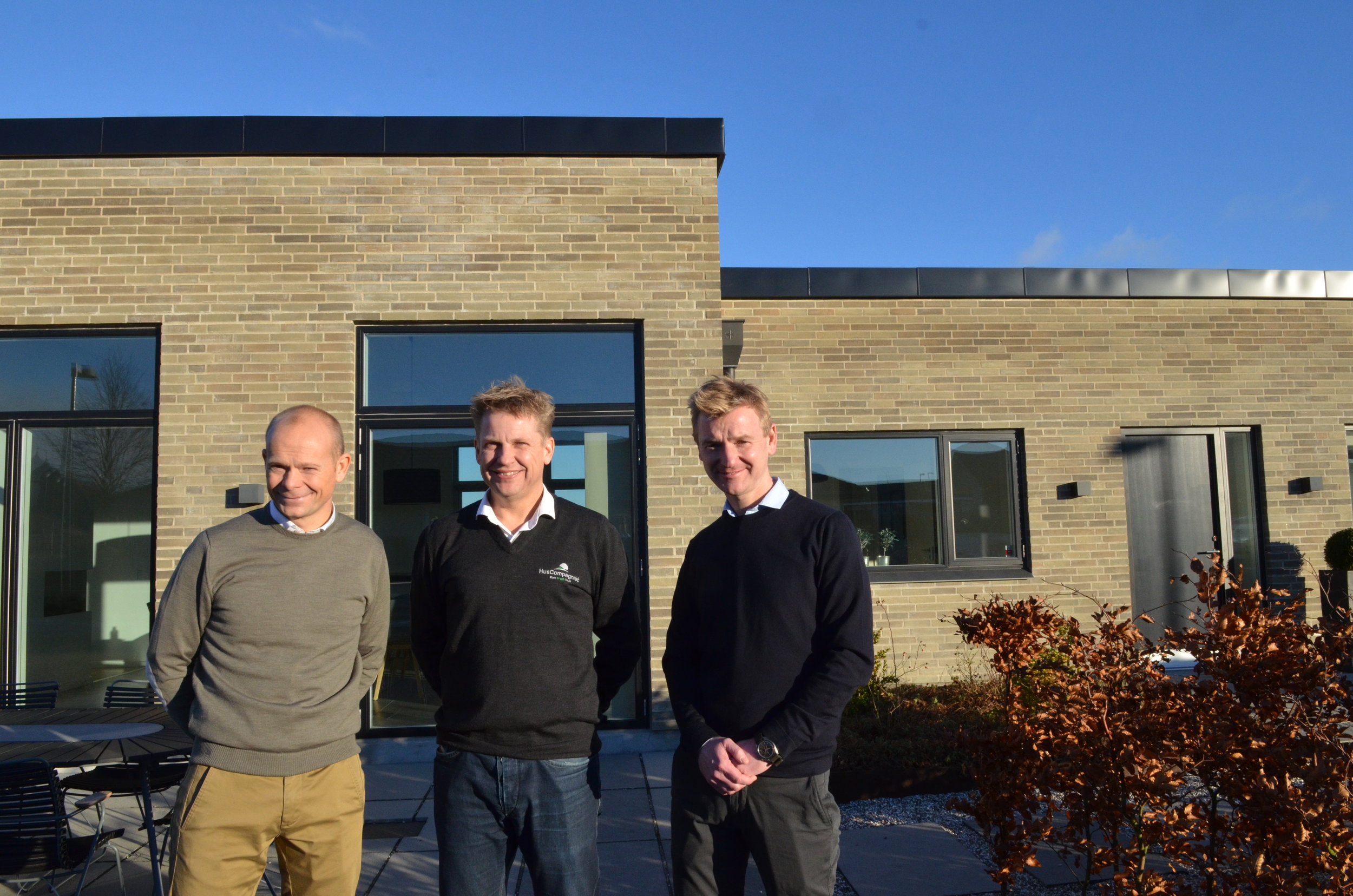 HusCompagniets afdelingsdirektør, Søren Ravn, flankeret af Jonas Berthelsen og Søren Due Hansen fra Land Development foran et af HusCompagniets huse i Hillerød. Foto: AOB