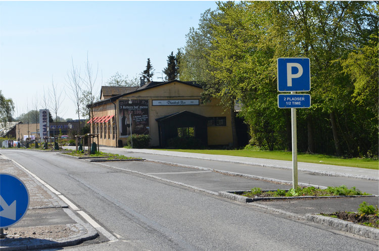 AOB foreslog i sin tid (den 22. maj), at kommunen burde placere et p-skilt ved de to p-lommer. Det skulle placeres, så det vendte mod bilisterne, som kom nordfra, så det tydeligt kunne læses, før man nåde frem til de to parkeringslommer. Vi foreslog samtidig underteksten: '2 pladser - 1/2 time'. Manipuleret foto: AOB