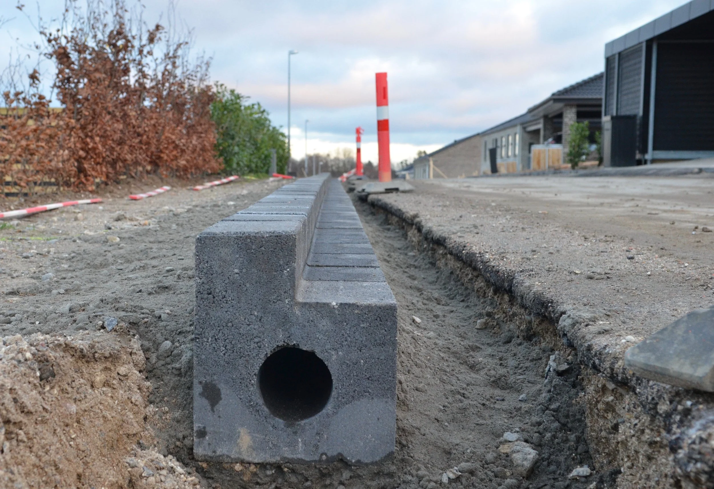 Systemet, som hedder d:RAin, består af en beton-vandrende, og er en kombination mellem et linjedræn og en vandrende. Det fungerer således, at vandet kan trænge igennem den øverste beton-del, mens den nederste del ikke er gennemtrængelig. Hullet i stenen virker som et afløsrør. Foto: AOB
