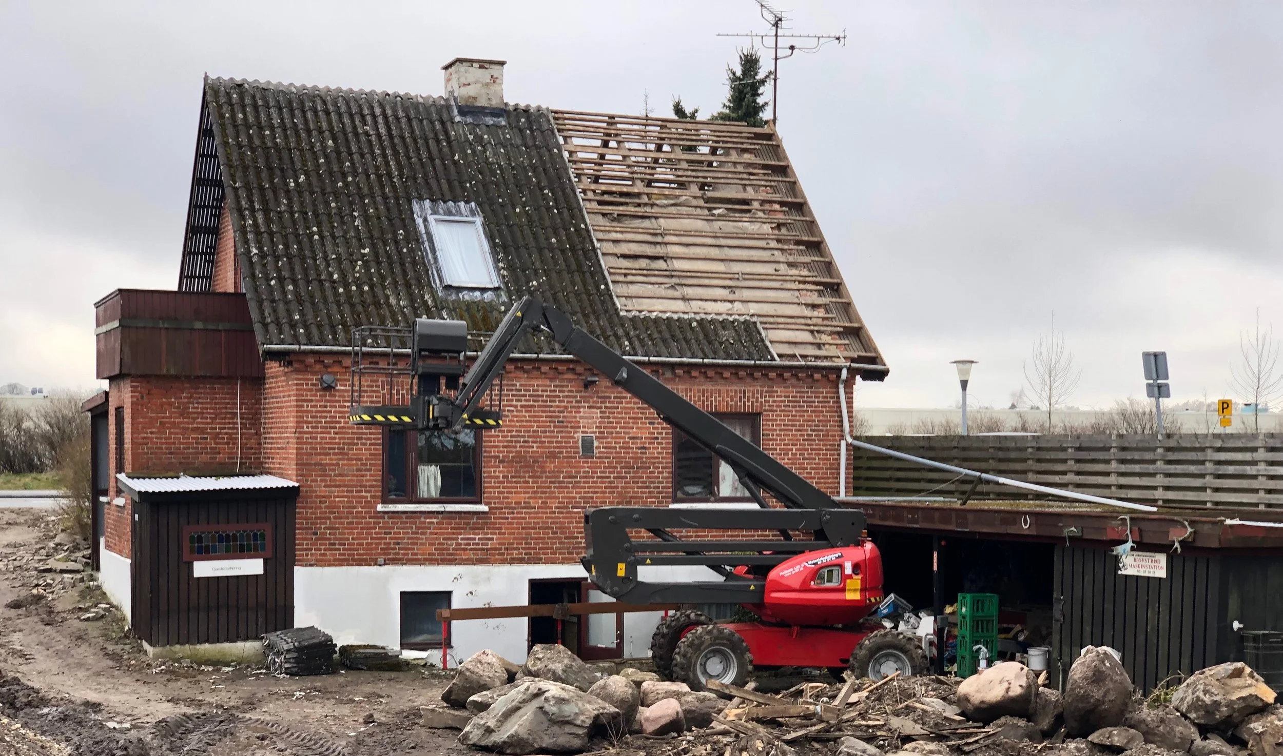 Entreprenøren er nu startet med nedrivningen af Kongevejen 28. Når huset er fjernet, skal grunden fyldes op i niveau med den eksisterende parkeringsplads. Foto: AOB