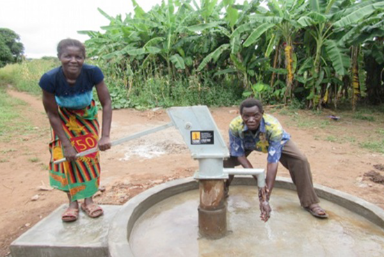 With smiling faces, the residents come to pump water from the well.