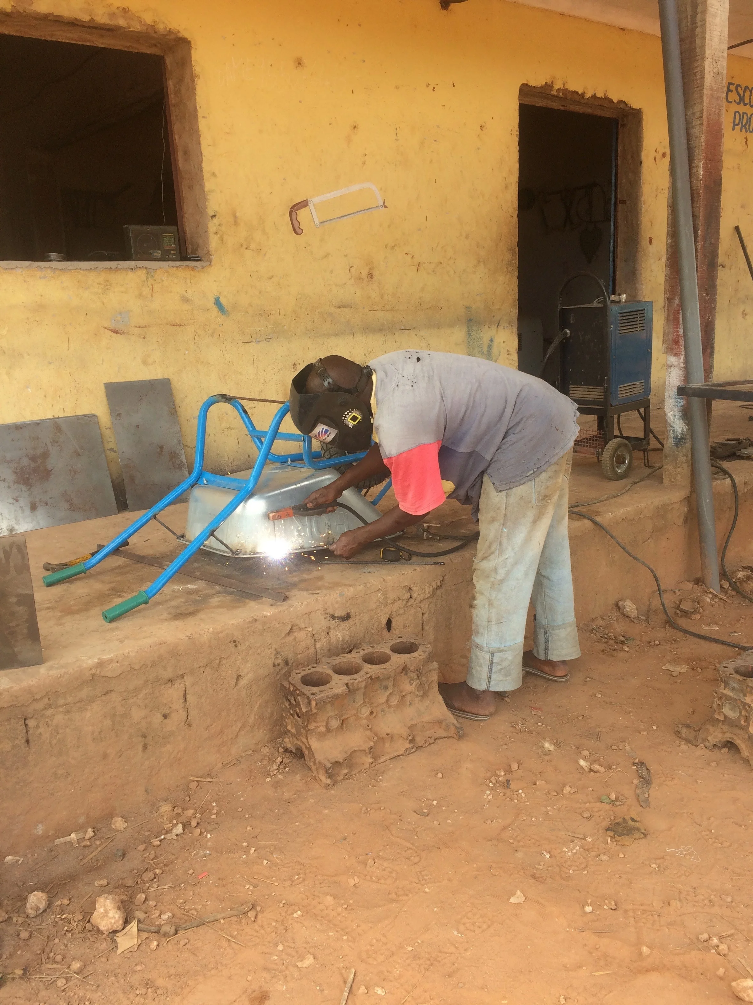 Welding a community member's wheelbarrow.