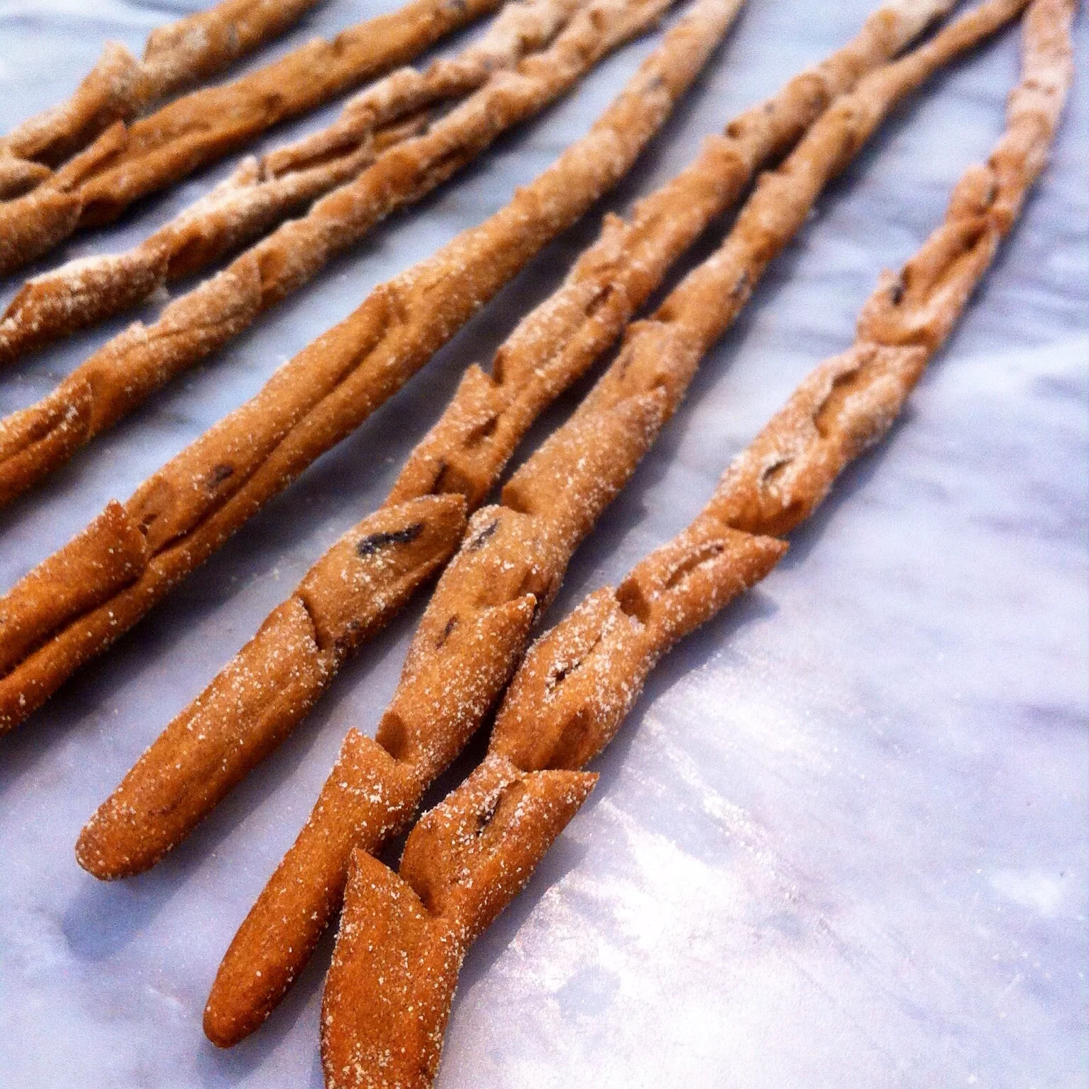 Snipping the grissini and giving it more of a branch or twig like shape makes for a more natural look and feel as well as exposing more of the surface to the oven. 