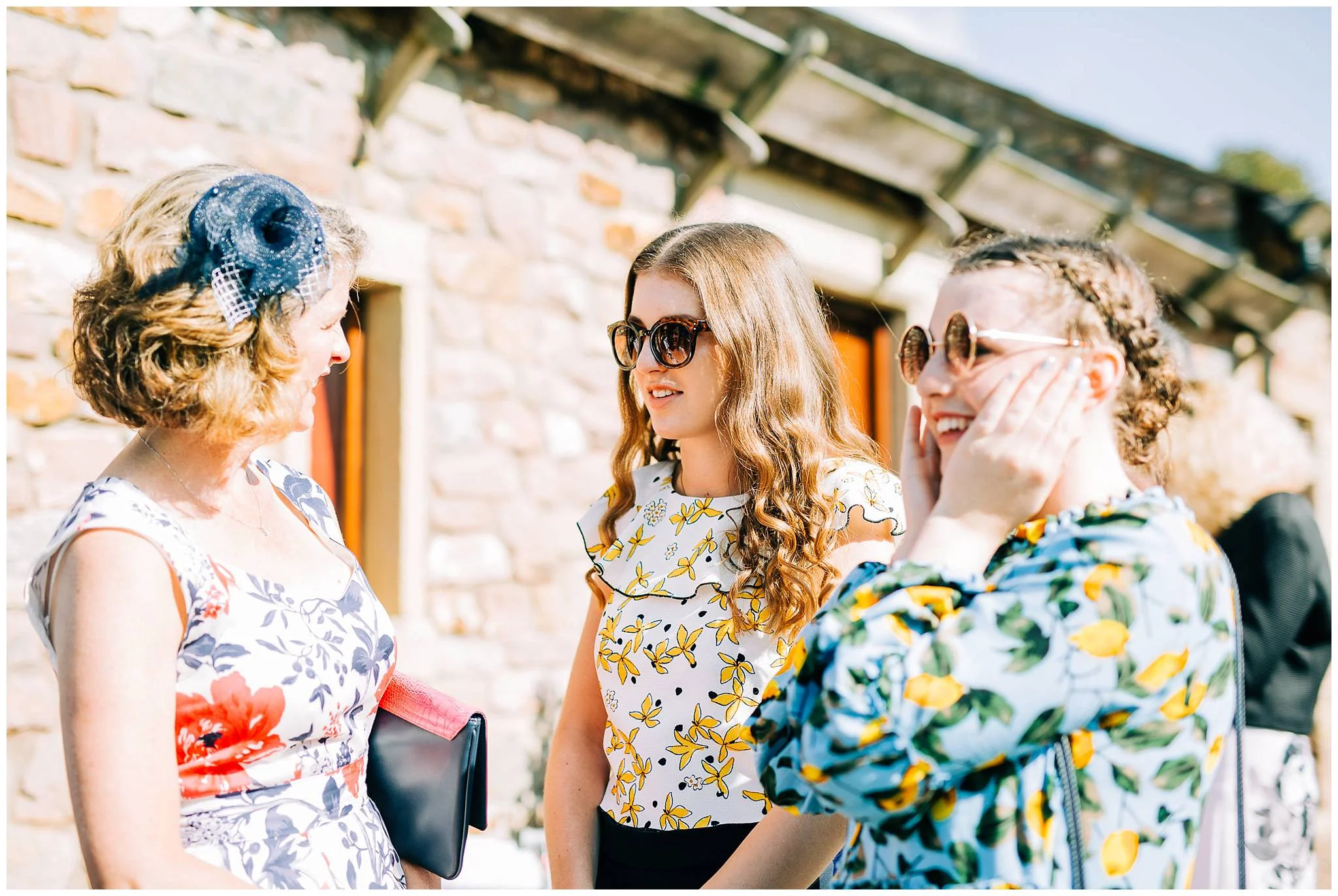 to fashionable girls wearing sunglasses are talking to her mother whislt outside the browsholme barn
