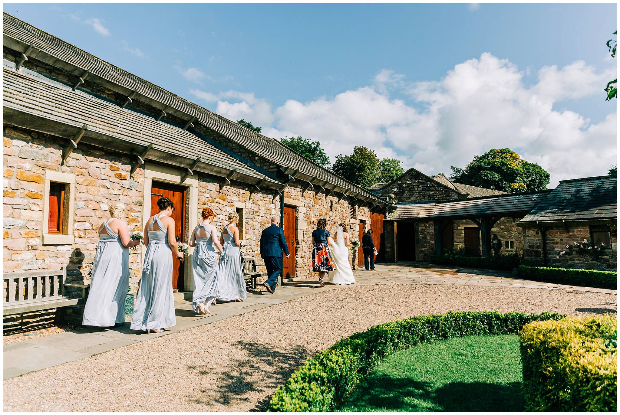 the remainging bridal party outside browsholme tithe barn are now walking in towards the entrance of the barn