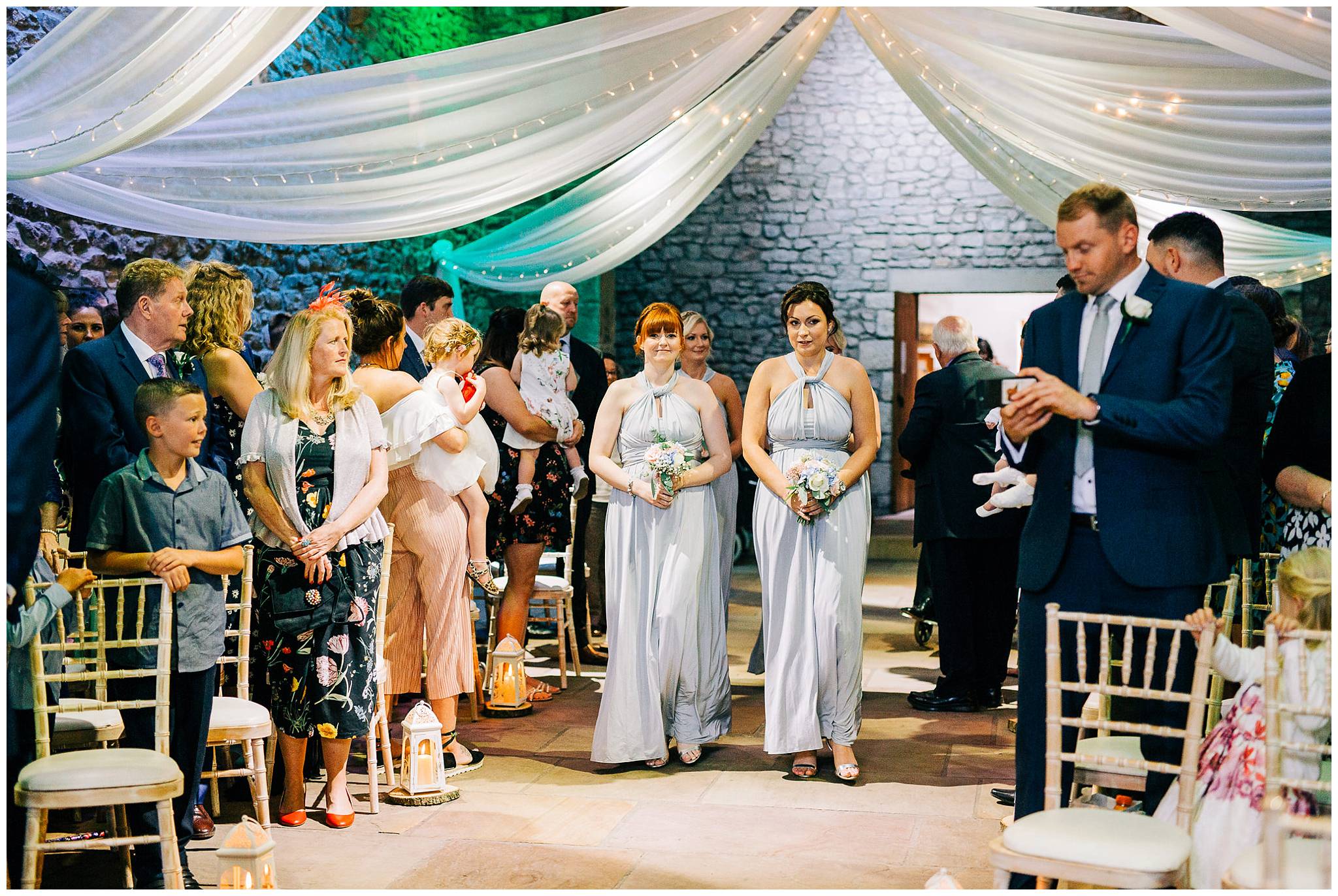 4 bridesmaids walking down the aisle at browsholme tithe barn