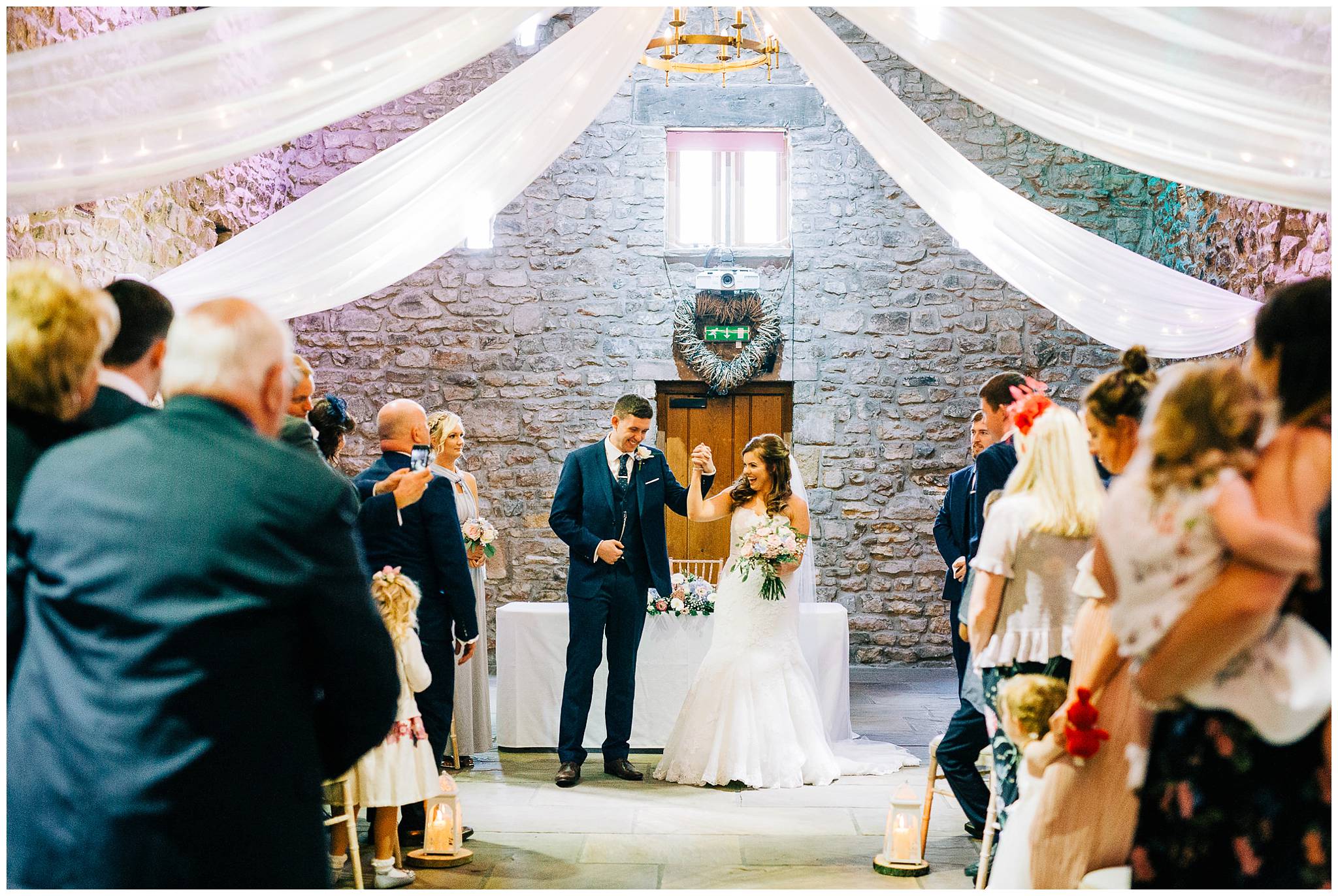 bride and groom punch air whilst holding hands after barn ceremony at browsholme hall titte barn